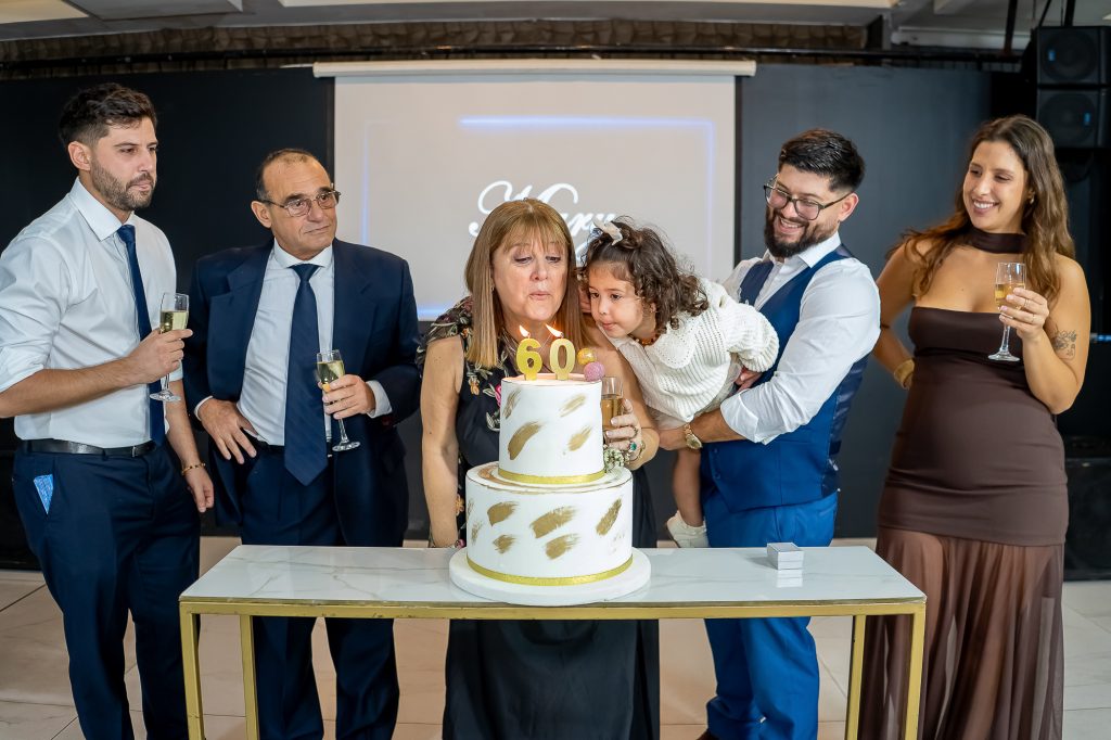 Cumpleaños de 60, foto soplando las velas de la torta de cumpleaños.
