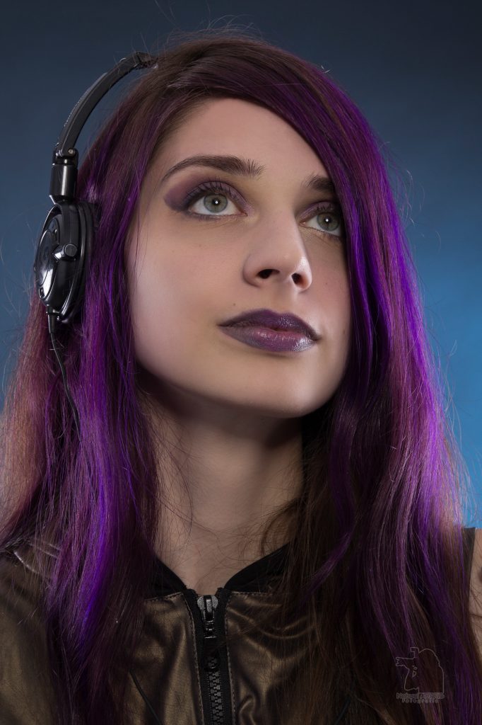 Retrato de chica con pelo violeta sobre fondo azul primer plano