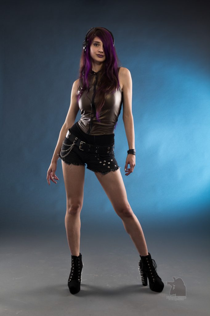 Retrato de chica con pelo violeta sobre fondo azul plano entero
