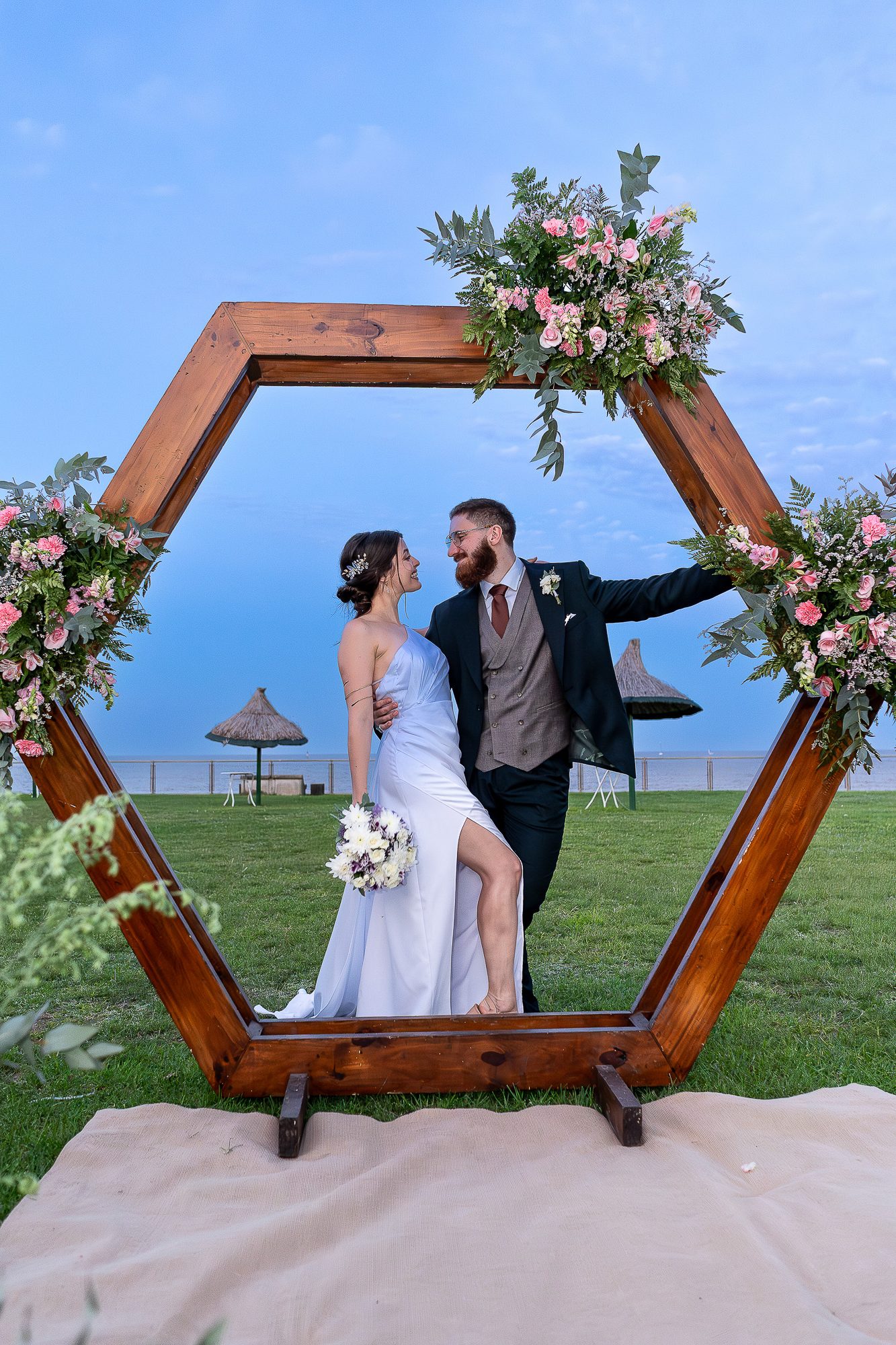 Boda frente al río en Olivos. Los novios se miran en la glorieta decorada con flores.