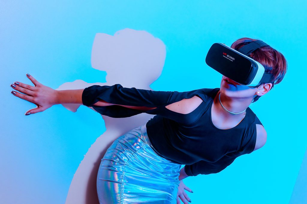 Produ de moda sobre futurismo usando la tendencia de ropa iridiscente. Foto de chica con VR y silueta de luz a plano americano