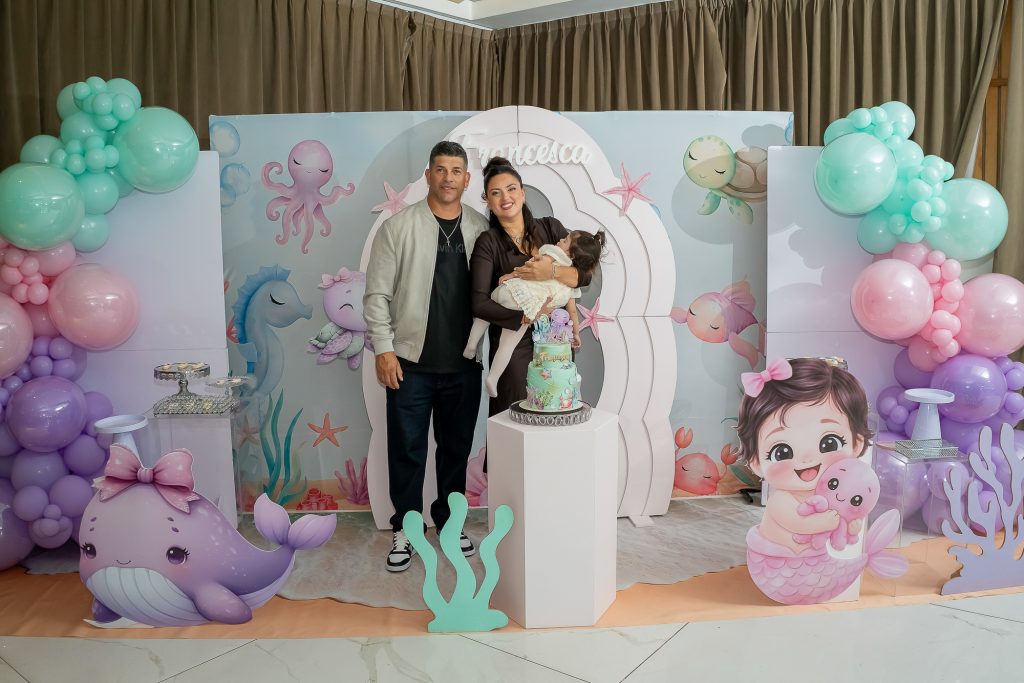 Cumple de 1 añito, pareja con beba en brazos frente a la torta.