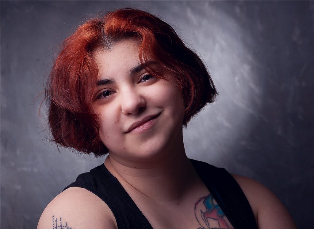 Retrato feminino en estudio, fondo jaspeado, luz lateral picada mas relleno.